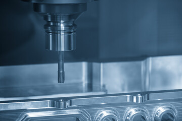 Fototapeta premium The tapping process on CNC milling machine with tapping tools.