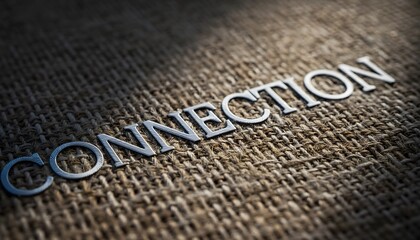The word "CONNECTION" in metallic letters on a tightly woven, dark, textured burlap or tapestry surface