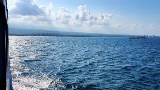 Bali, Indonesia - August 27, 2025: Car and passenger ferries cross the Bali Strait from Gilimanuk Harbor to Ketapang Harbor. View of the strait from the ferry deck. 4К