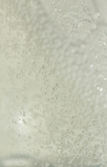 bottle of yellow hair oil with foam, shampoo, cleanser, macro texture of oil with bubbles, cosmetic textures, skincare product liquid