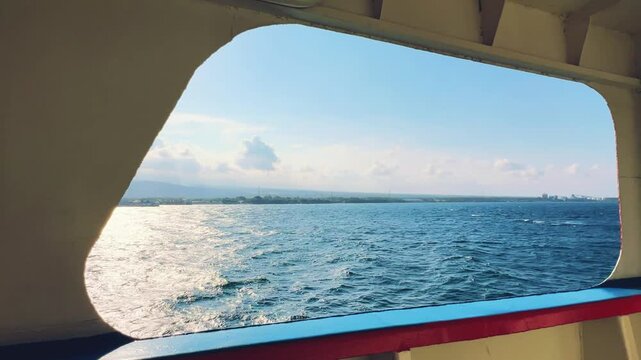Bali, Indonesia - August 27, 2025: Car and passenger ferries cross the Bali Strait from Gilimanuk Harbor to Ketapang Harbor on the island of Java. View of the strait from the ferry deck. 4K