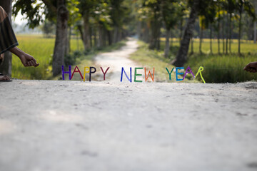 Colorful letters spell out happy new year on a dirt road