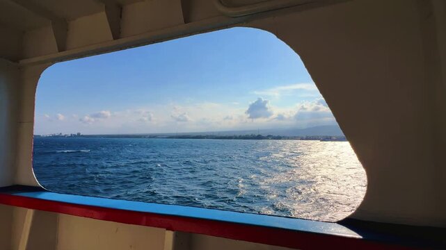 Bali, Indonesia - August 27, 2025: Car and passenger ferries cross the Bali Strait from Gilimanuk Harbor to Ketapang Harbor on the island of Java. View of the strait from the ferry deck. 4K