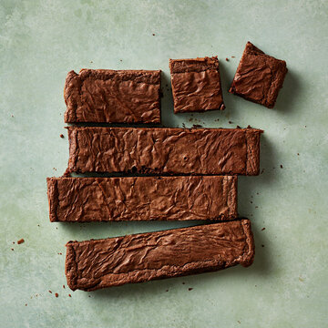 Chocolate Brownie Pieces Arranged on Green Background Flat Lay