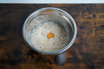Egg added to activated yeast while preparing dough for baking