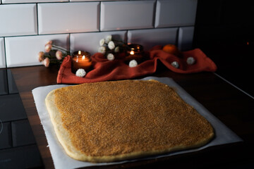 Rolled out dough on the table sprinkled with cinnamon and sugar, making Cinnabons