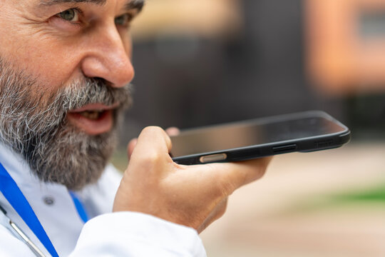 Doctor recording voice message on smartphone for communication