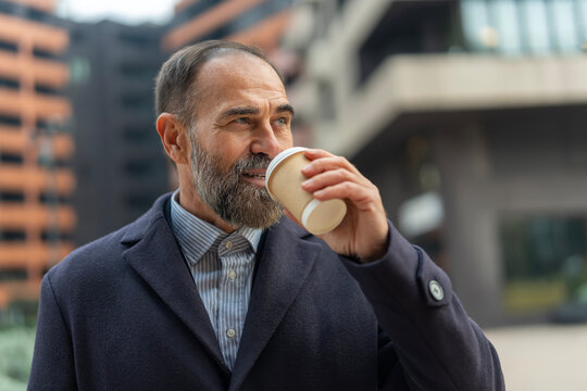 Mature businessman enjoying coffee break in urban setting