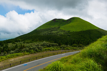 Lush green hillsides around Mt. Aso close to Nakadake Crater with views on the cone of Komezuka crater and other peaks, Kumamoto, Japan