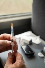 Close-up of insulin syringe filled for diabetes treatment on train table