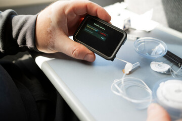 insulin pump, priming tubing, insulin pump screen, infusion Priming insulin pump tubing on a train table during diabetes management routine