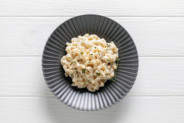 American simple dish mac and cheese. Pasta with cheese and cream sauce in a plate on the table. Top view