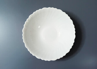 Empty White Soup Plate with Wavy Edge on gray Background