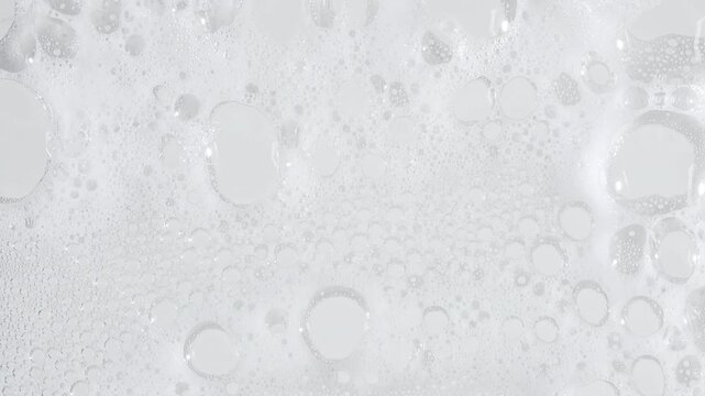 Bubbles of white soap foam. Moving Soap foam popping bubble on a white backdrop. Soap sud macro structure. Clean, cleaning concept, laundry, shower. . High quality 4k footage