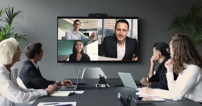 Diverse businesspeople participate in videocall, displayed on tv screen