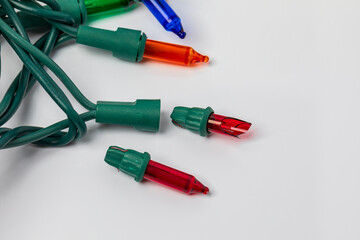 Replacing bad bulb in Christmas string lights. Holiday lighting repair, safety and decoration concept.