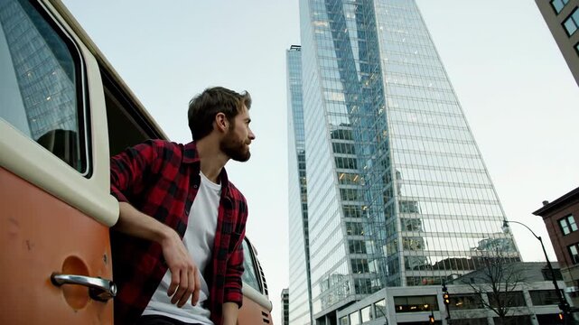 A man in a plaid shirt leans out of a vintage van looking at modern skyscrapers symbolizing urban lifestyle contrast