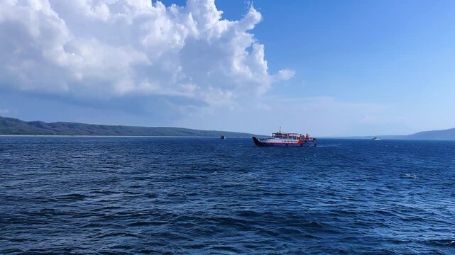 Bali, Indonesia - August 27, 2025: Car and passenger ferries cross the Bali Strait from Gilimanuk Harbor to Ketapang Harbor on the island of Java. View of the strait from the ferry deck. 4K