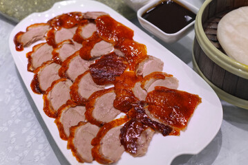 Sliced Peking Duck Served on White Plate with Hoisin Sauce and Steamed Pancakes &ndash; Traditional Chinese Cuisine