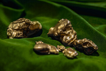 Gold nuggets on velvet fabric. Wealth, investment, luck and success concept