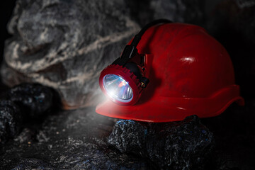 Protective miner's helmet, hard hat with a flashlight in a mine underground in a tunnel in the...