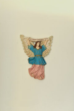 religious decoration, Religious wall carving of an angel holding a banner inscribed "GLORIA IN EXCELSIS DEO", traditional folk art sculpture, vertical
