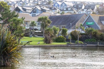A picturesque seaside town viewed across a tranquil body of water in Perranporth - Cornwall - UK