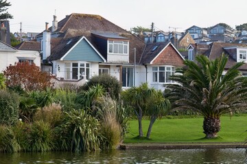 Residential seaside cottages are featured, nestled among lush greenery and palm trees in Perranporth - Cornwall - UK