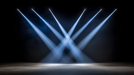 The image features a dark stage illuminated by several beams of blue light, creating a dramatic and theatrical effect that highlights the center and adds depth to the dark background.