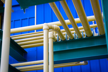 The yellow chemical pipelines inside the factory are arranged in an orderly and engineered manner, representing precision,