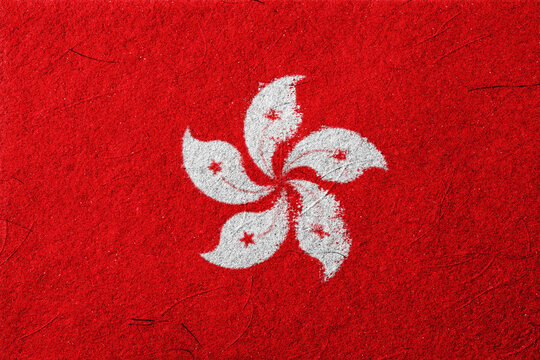 The image presents a detailed close-up of a textured red surface, prominently featuring a stylized, white five-petal flower with a red star at the center of each petal, evoking a sense - Powered by Adobe