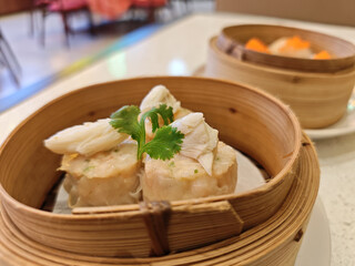 Crab dim sum steamed dumpling bamboo steamer seafood appetizer garnish asian cuisine restaurant lunch traditional food Steamed crab dim sum dumpling bamboo steamer with seafood filling and fresh