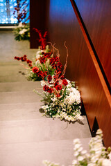 Elegant red and white floral arrangements decorating a modern staircase