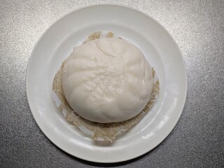 白い皿に温かく蒸された中華まん（肉まん・あんまん）の真俯瞰