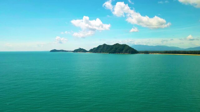 Aerial view of Pantai Bukit Keluang, Besut, Terengganu, showing turquoise waters, coastal cliffs, and clear sunny skies along the scenic shoreline.
