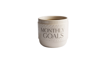 A cup filled with dark beverage, inscribed with the words MONTHLY GOALS.