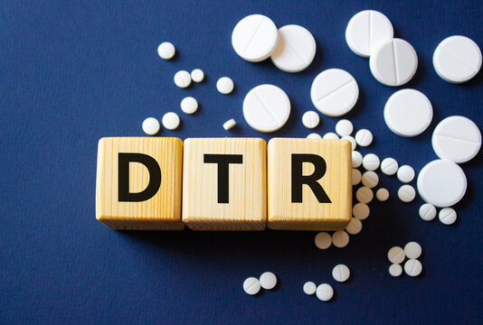 DTR symbol. Wooden cubes with words DTR Deep tendon reflexes. Beautiful deep blue background. Healthcare and Deep tendon reflexes concept. Copy space.