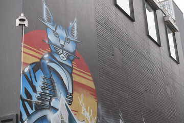 Fototapeta premium mural of a cat on the west facing wall of the newly constructed (2021) Scott Mission (seen from St Andrew St), near Kensington Market, Toronto
