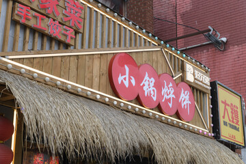 Fototapeta premium exterior of a restaurant, 好兄弟小锅烀饼 (XiaoGuoHuBing), located at 460 Dundas St W in Chinatown, Toronto - Big Trouble bar and cocktail lounge