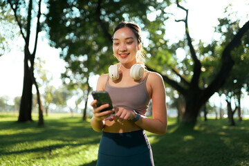 Young woman checking fitness app on smartphone in park