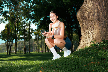 Asian woman taking break with phone in park
