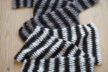 Close-up of two handmade scarfs made of Mohair, Polyamide and acrylic lying on oak wooden parquet floor. Photo taken November 16th, 2025, Zurich, Switzerland.