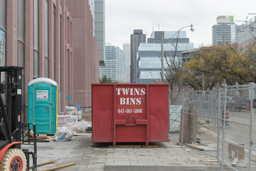 Fototapeta premium Twins Bins Disposal Inc metal container at a construction site in the Canary District (Cherry St), Toronto