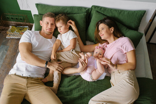 Mother And Father Playing With Kids In Home - Powered by Adobe