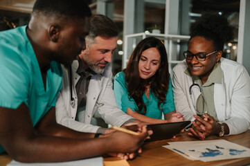 Diverse medical team collaborating on digital tablet in hospital