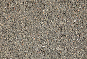 Detailed view of faded asphalt surface, background. Texture of an old bitumen close-up with abstract pattern. Worn out stone backdrop. Road foundation, based on crushed stone and resin. Road backdrop