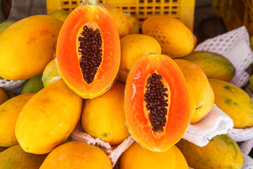 Close up of ripe papayas displayed for sale at traditional food market in Phu Quoc, Vietnam. Vietnamese street market. Agriculture, farming and harvest concept