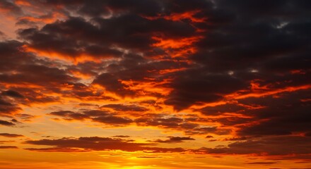 Fototapeta premium Fiery sunset displays rich orange and dark clouds, painting the sky with dramatic colors