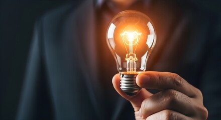 Brilliant idea strikes man in suit holding glowing light bulb illuminating innovation and inspiration for creative solutions