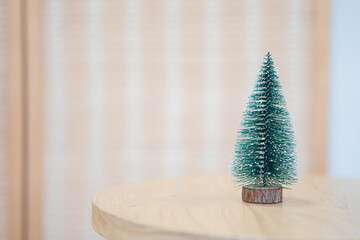 Mini Christmas tree on wooden table. Minimal trendy Christmas decoration.